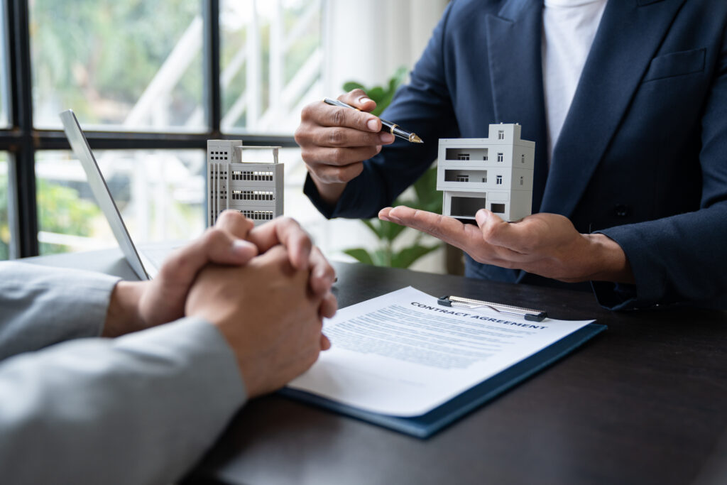 Entrepreneur, business owner, accountant, real estate agent A young Asian insurance agent explains the details of the condo purchase contract to calculate the financial risk for the client.